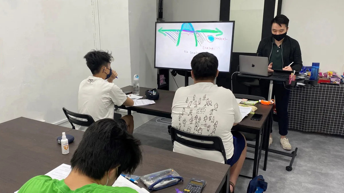 A Math Vigilante tutor teaching a small secondary math class, working on the screen
